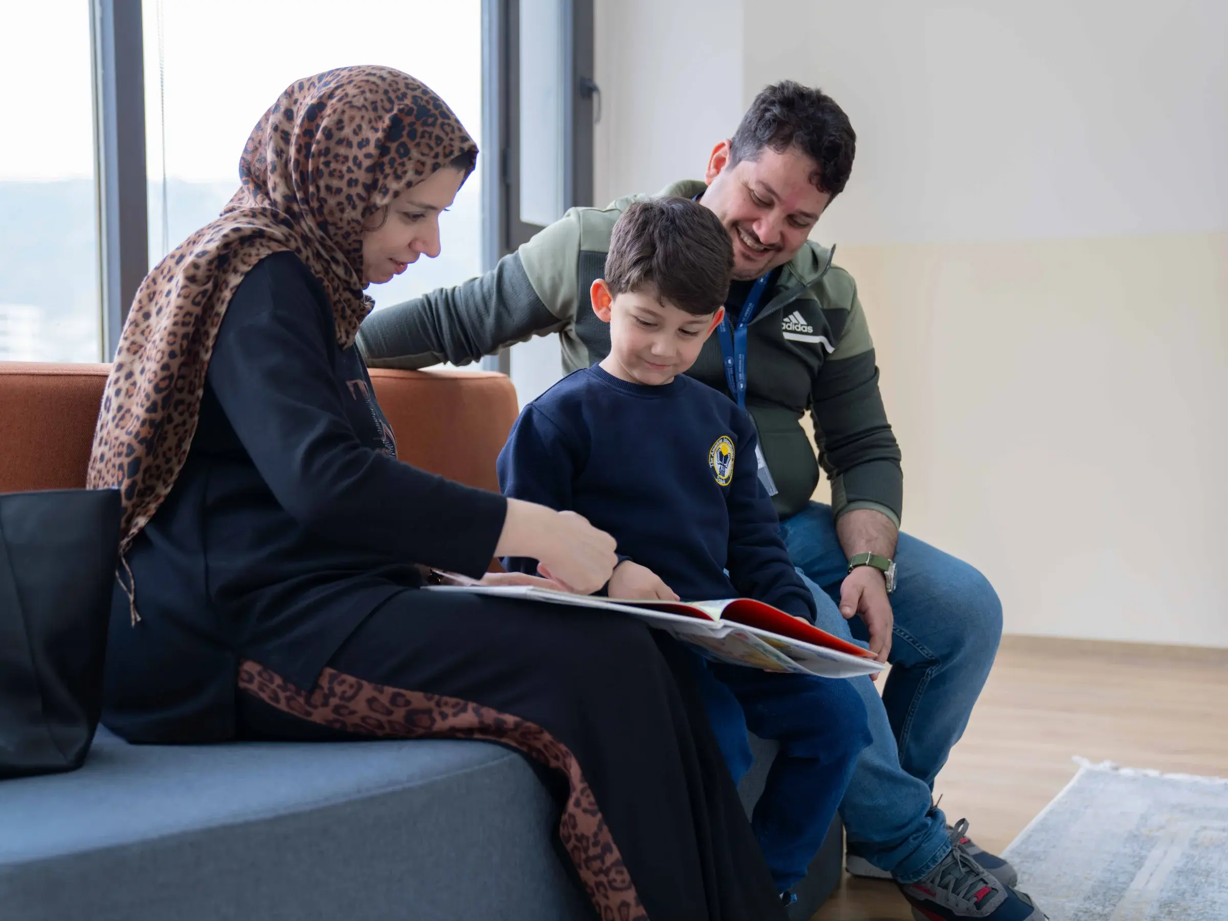 A family reading together in the AIS library